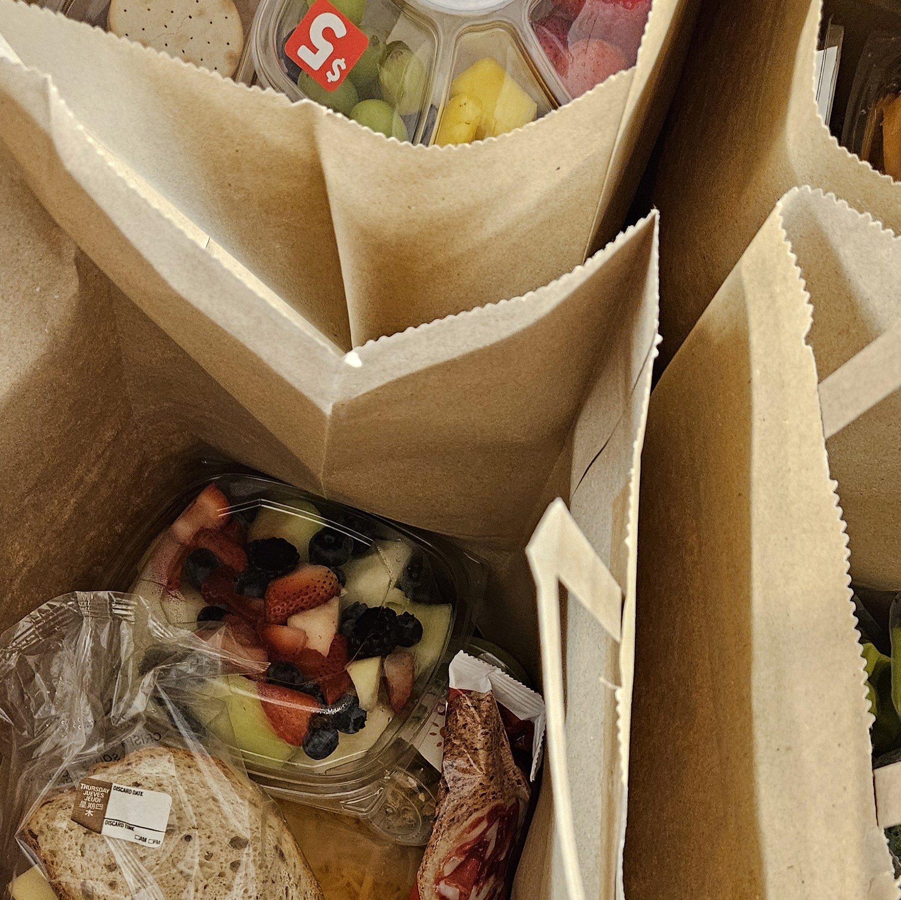 paper bags filled with bread and fruit bowls at food pantry