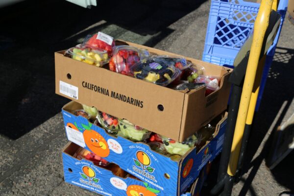 3 boxes of fruit bowls loaded on hand cart at food bank