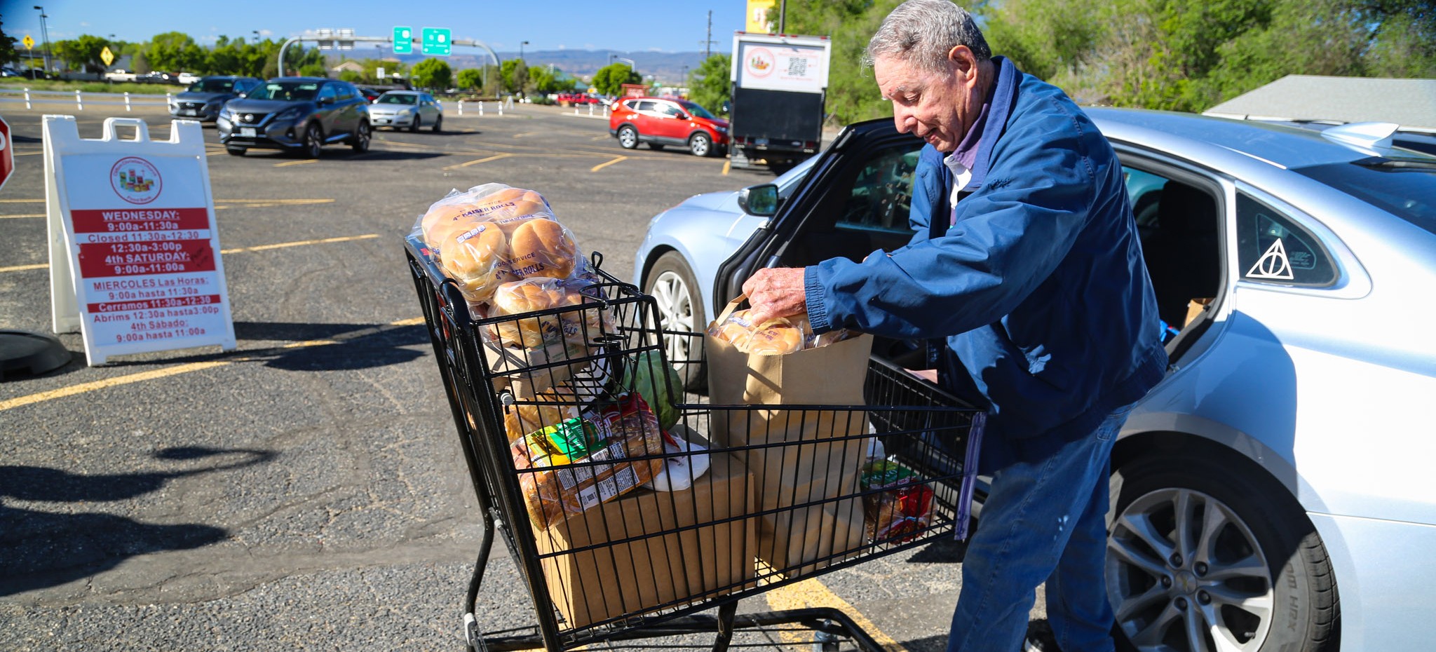 man loads bags of food into car at food pantry